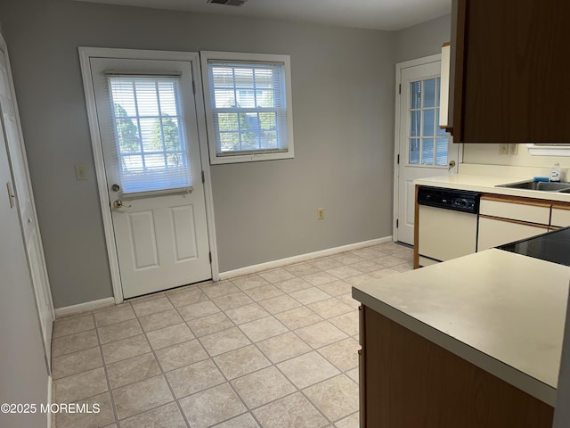 kitchen featuring light countertops, dishwasher, visible vents, and baseboards