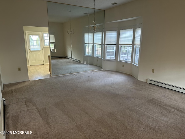 spare room with light carpet, a chandelier, and visible vents