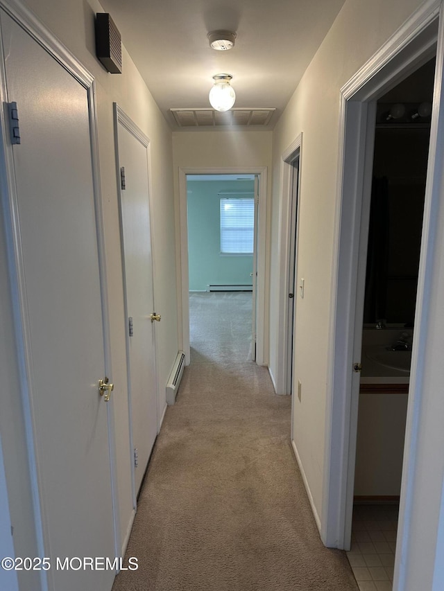 corridor featuring a baseboard heating unit, visible vents, baseboard heating, and light colored carpet