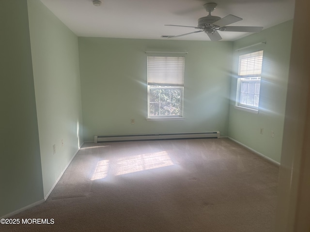 spare room featuring ceiling fan, baseboards, baseboard heating, and light colored carpet