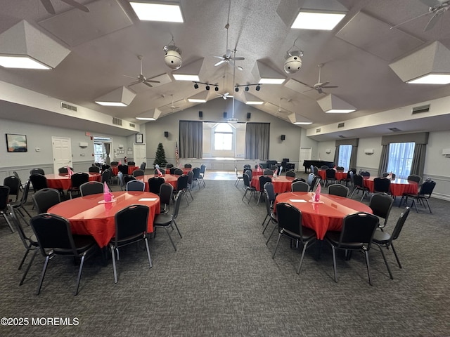 dining area with a wealth of natural light, dark colored carpet, visible vents, and vaulted ceiling