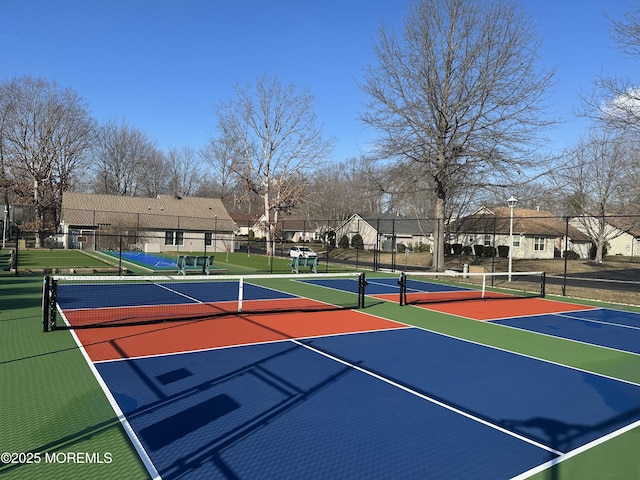 view of tennis court with a residential view, community basketball court, and fence