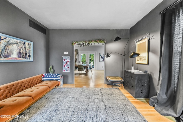 living area featuring light wood finished floors and french doors