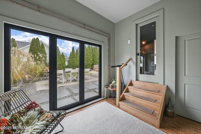 doorway to outside featuring light wood-style floors and stairway