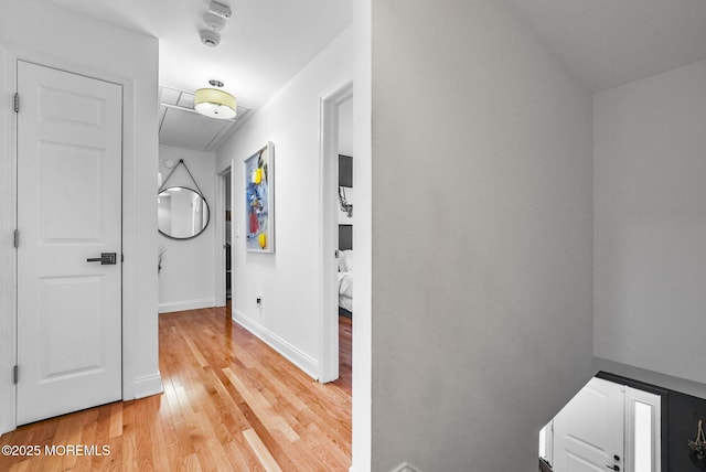 hallway with light wood-style flooring and baseboards