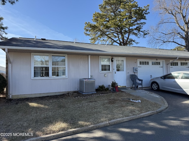 single story home featuring an attached garage and cooling unit