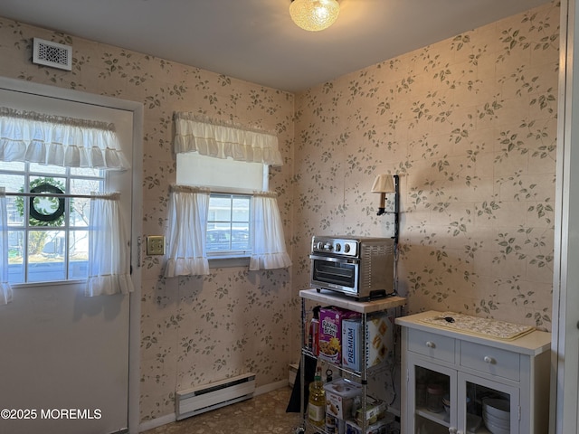 kitchen featuring wallpapered walls, visible vents, glass insert cabinets, and baseboard heating