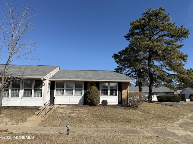 ranch-style house featuring a shingled roof