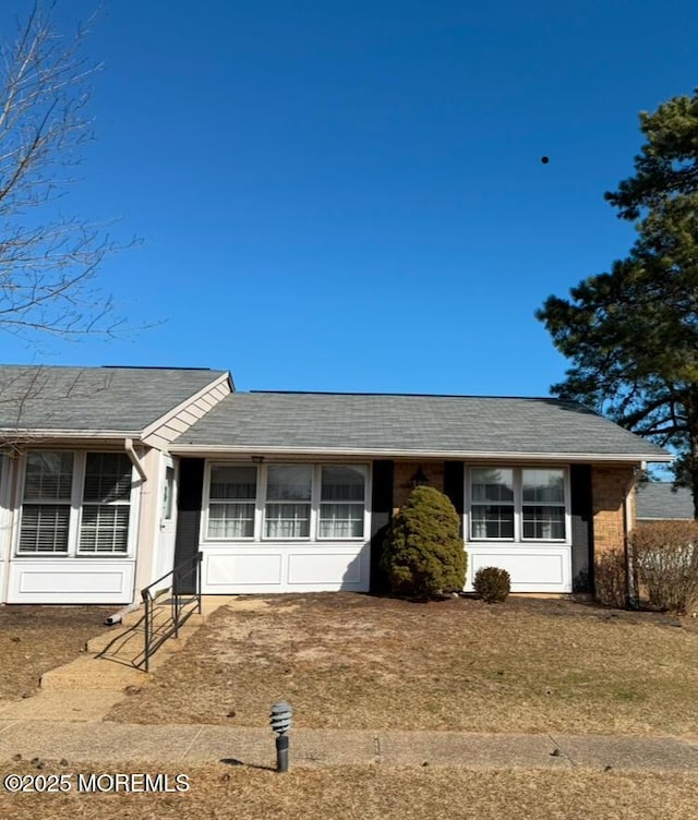 single story home with a front lawn and roof with shingles