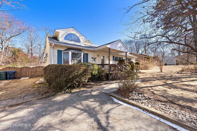 view of front of house with covered porch and fence