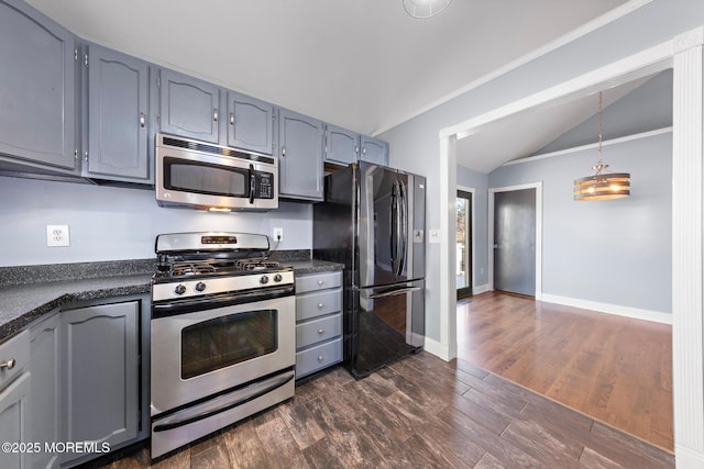 kitchen featuring baseboards, dark countertops, dark wood-style floors, vaulted ceiling, and stainless steel appliances