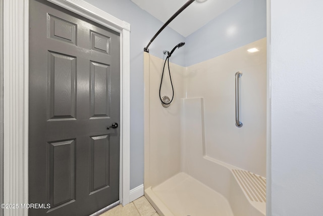 bathroom with a shower stall and tile patterned floors