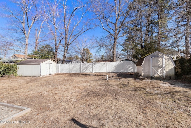 view of yard with an outbuilding, a storage unit, and fence