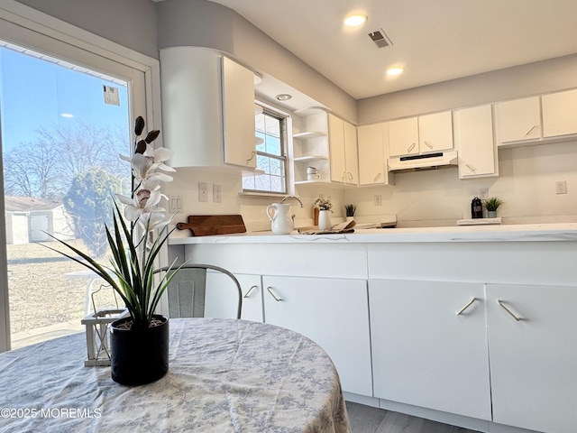 61B Hedge Dr, Lakewood, NJ 08701 - kitchen with visible vents, under cabinet range hood, open shelves, white cabinetry, and light countertops