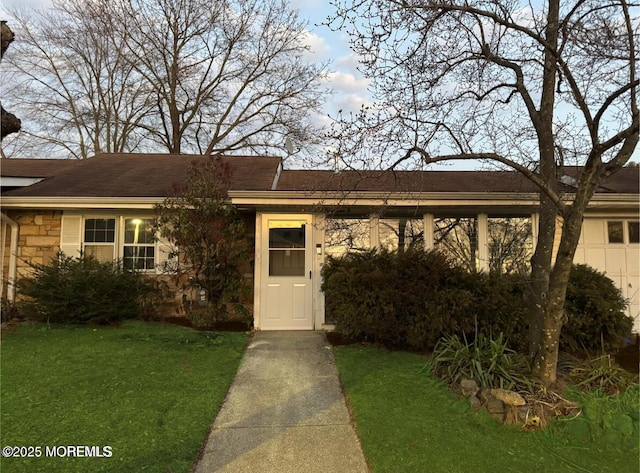 single story home with stone siding and a front lawn