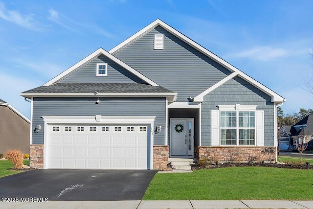 craftsman-style house featuring an attached garage, a shingled roof, stone siding, driveway, and a front lawn