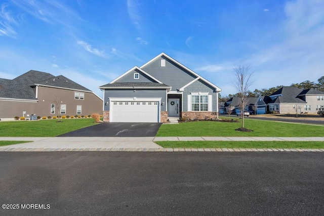 view of front of home featuring stone siding, driveway, a front lawn, and an attached garage