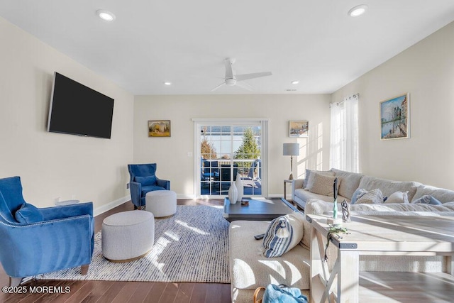 living area with baseboards, wood finished floors, a wealth of natural light, and recessed lighting