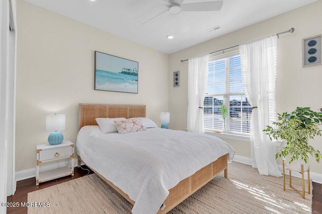 bedroom featuring visible vents, baseboards, ceiling fan, and wood finished floors