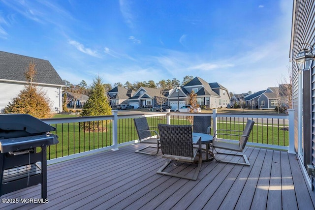 wooden terrace featuring a yard, a grill, and a residential view