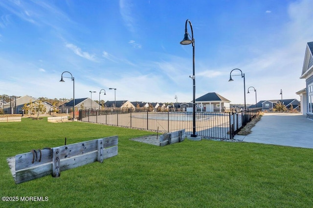 view of community with a lawn and fence