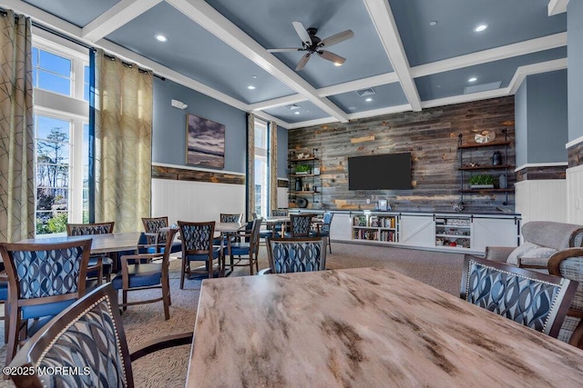 dining room with coffered ceiling, ceiling fan, beamed ceiling, wood walls, and recessed lighting