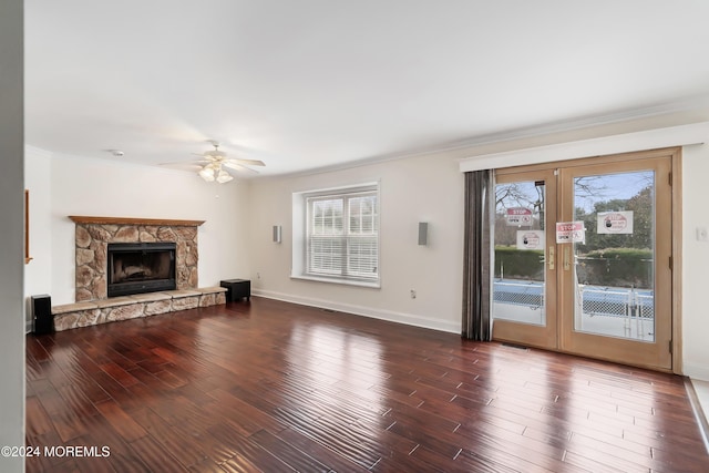 unfurnished living room featuring french doors, a fireplace, dark wood finished floors, and baseboards