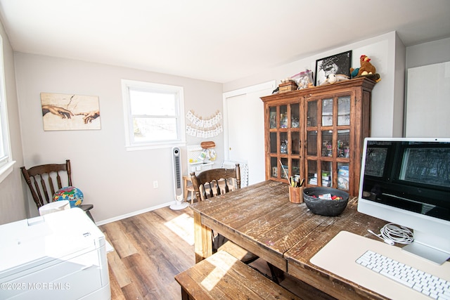 dining space featuring baseboards and wood finished floors