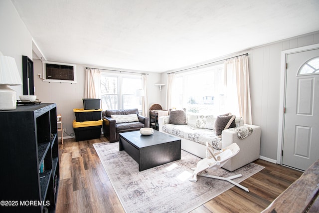 living area featuring dark wood-style floors and a wall mounted air conditioner