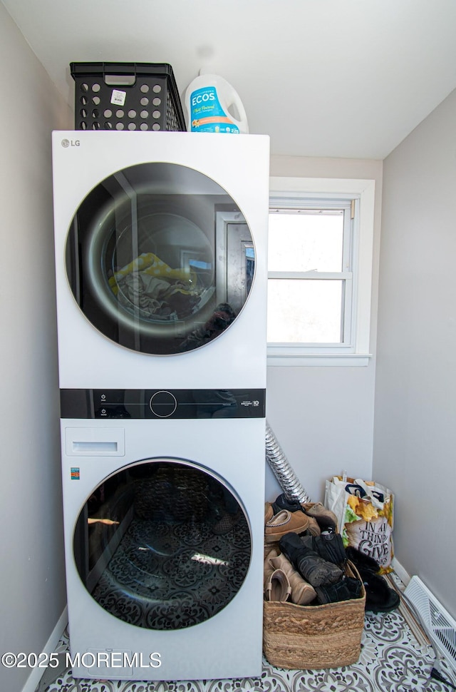 laundry area with stacked washer / dryer, laundry area, visible vents, and baseboards