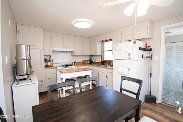 kitchen with tasteful backsplash, white appliances, white cabinets, and under cabinet range hood