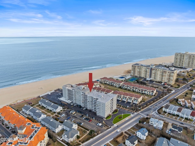 birds eye view of property with a water view and a beach view