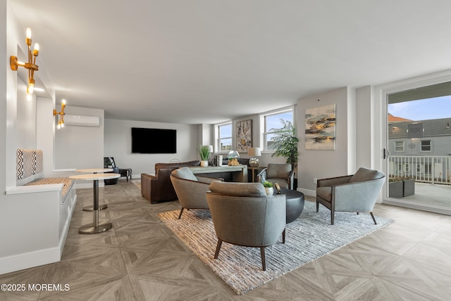 living room featuring baseboards and a wall mounted air conditioner