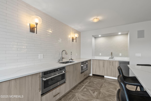 kitchen with a sink, stainless steel oven, and decorative light fixtures