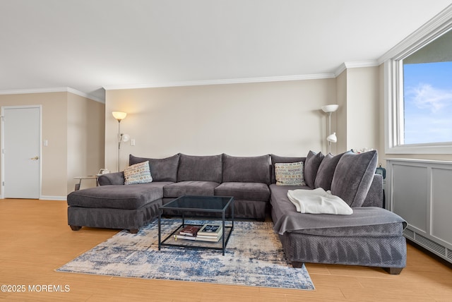 living area featuring light wood-style floors, baseboards, visible vents, and crown molding