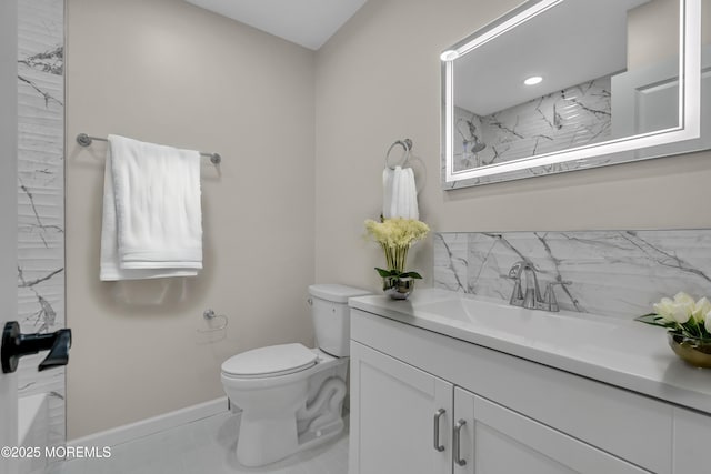 bathroom featuring toilet, baseboards, and vanity