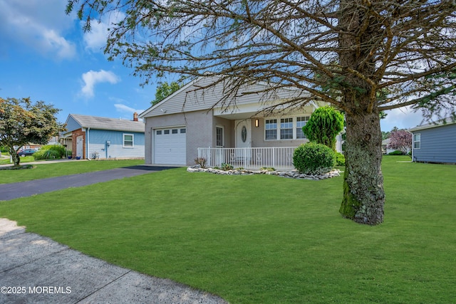 view of front of home with a garage, driveway, brick siding, and a front yard