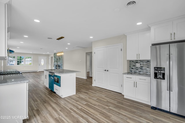 kitchen with light stone counters, appliances with stainless steel finishes, an island with sink, and white cabinetry