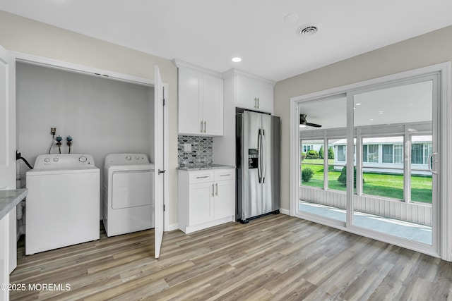 laundry room featuring light wood-type flooring, laundry area, visible vents, and washing machine and clothes dryer