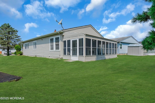 back of property featuring a sunroom, a storage unit, and a lawn