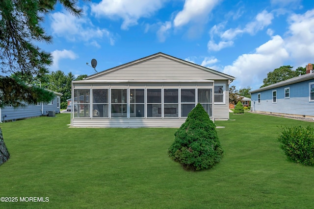 rear view of house with a sunroom and a lawn