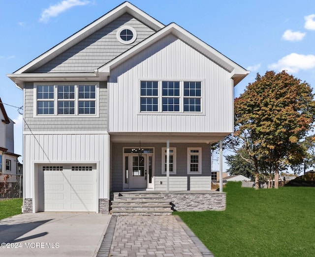 view of front of house featuring a garage, a porch, a front lawn, and concrete driveway