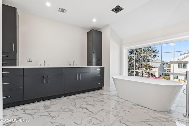 full bath with a freestanding tub, recessed lighting, visible vents, marble finish floor, and double vanity