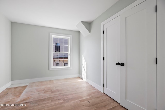 unfurnished bedroom with baseboards and light wood finished floors