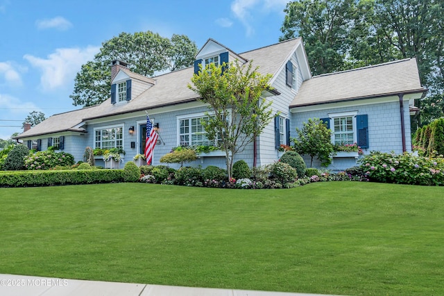 cape cod home with a chimney and a front lawn