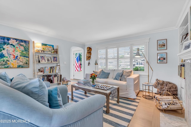 living room featuring light wood finished floors, arched walkways, and ornamental molding