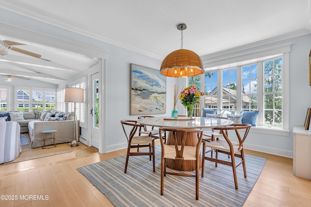 dining area featuring a baseboard heating unit, baseboards, crown molding, and light wood finished floors