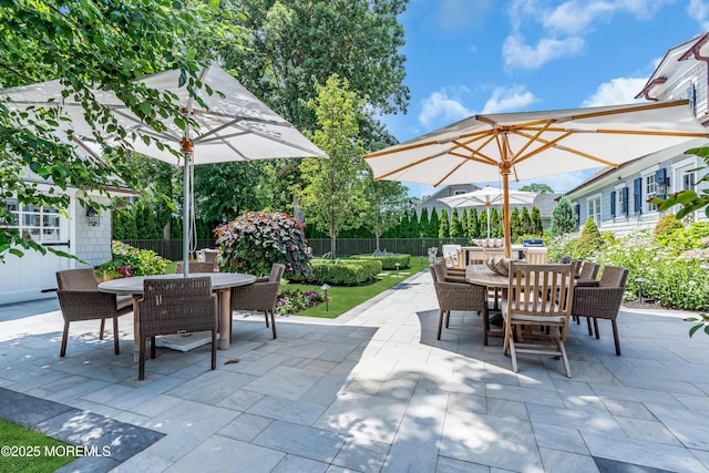 view of patio / terrace with outdoor dining space, fence, and an outdoor structure