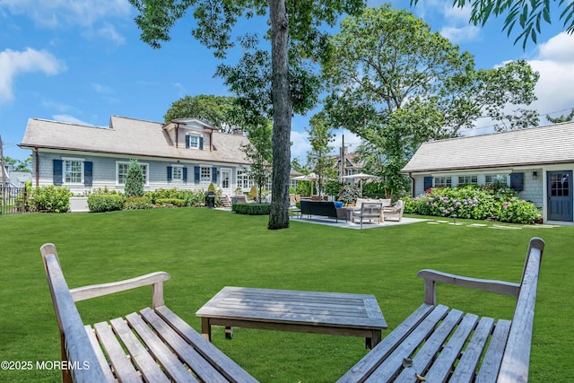 view of community featuring an outdoor hangout area, a patio, a lawn, and fence