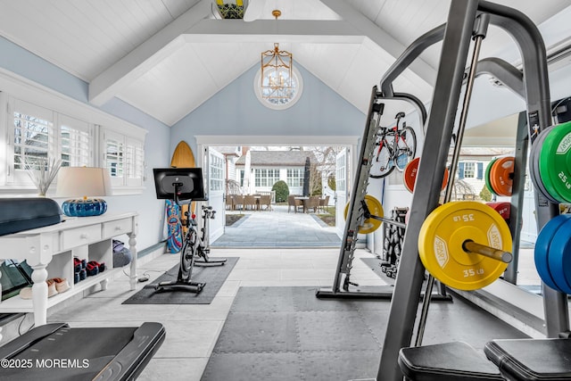 exercise area featuring vaulted ceiling and a notable chandelier